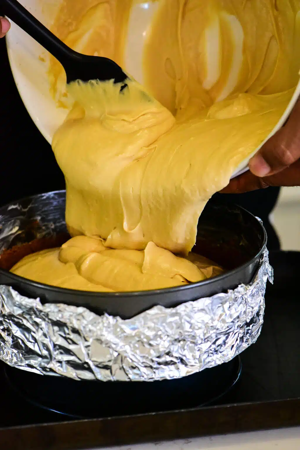 add the cheesecake filling to the spring form pan on top of the cookie crust
