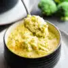eating broccoli cheese soup with a spoon
