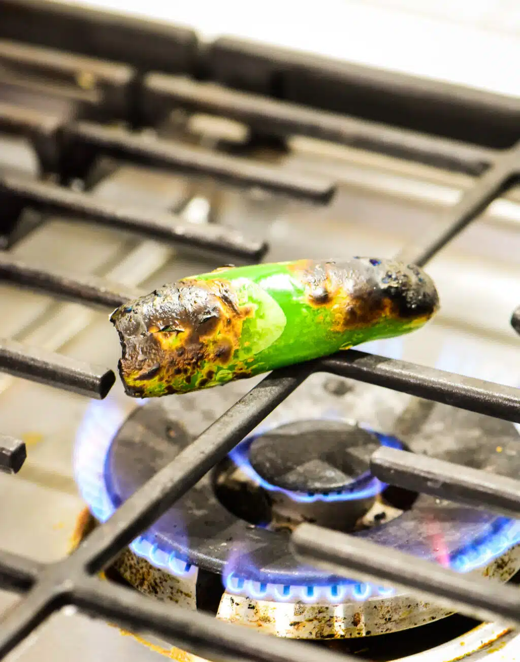 charring a fresh jalapeno over an open flame