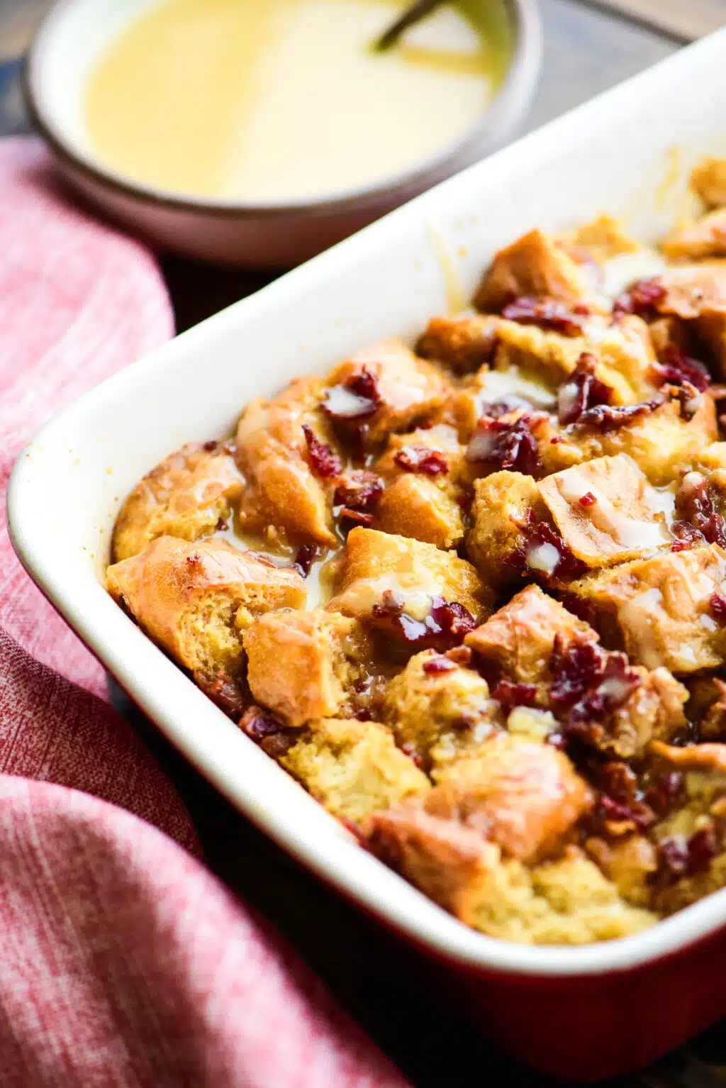 maple bacon bread pudding in a casserole dish served with maple brown sugar sauce
