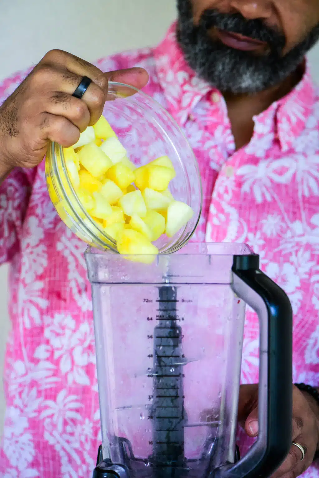 adding frozen pineapples to a blender
