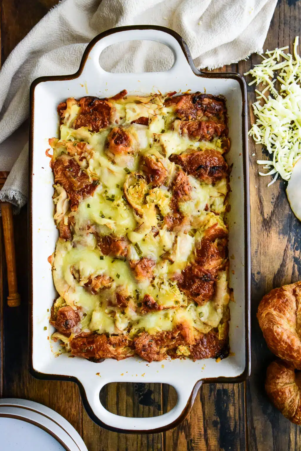 overhead shot of a turkey and cheese croissant bake served in a casserole dish