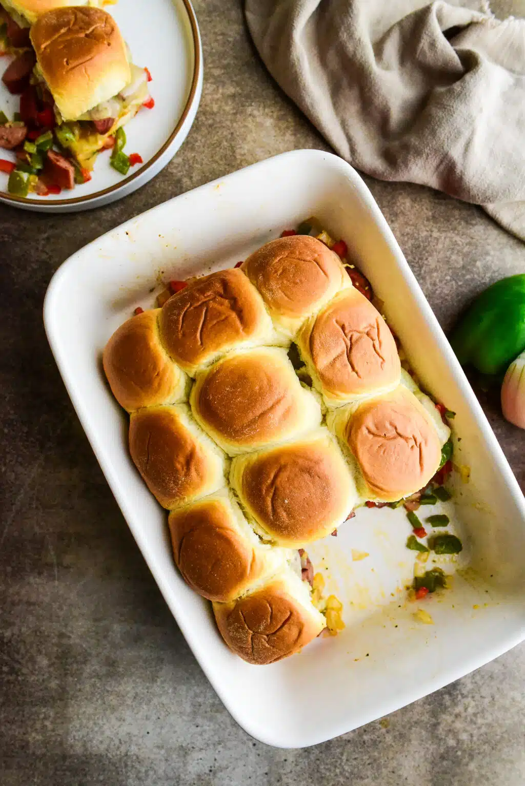 overhead shot of sausage & peppers sliders in a casserole dish