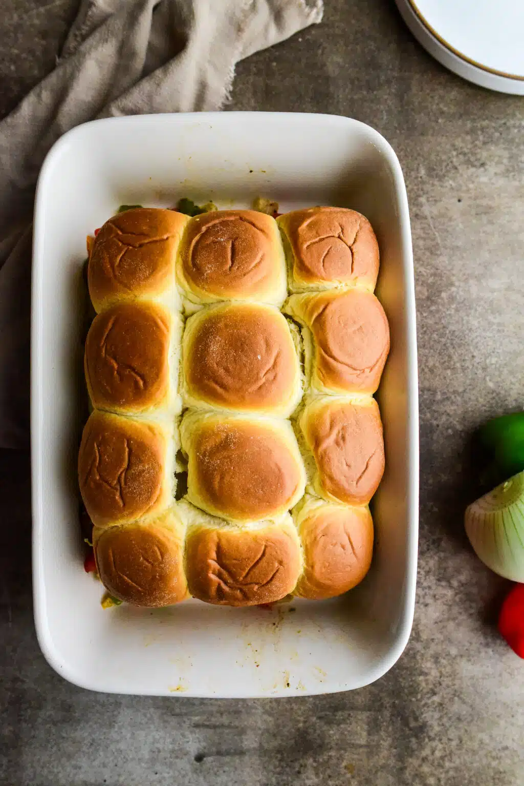 overhead shot of baked sausage and peppers sliders