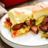 two servings of sausage & pepper sliders on a plate