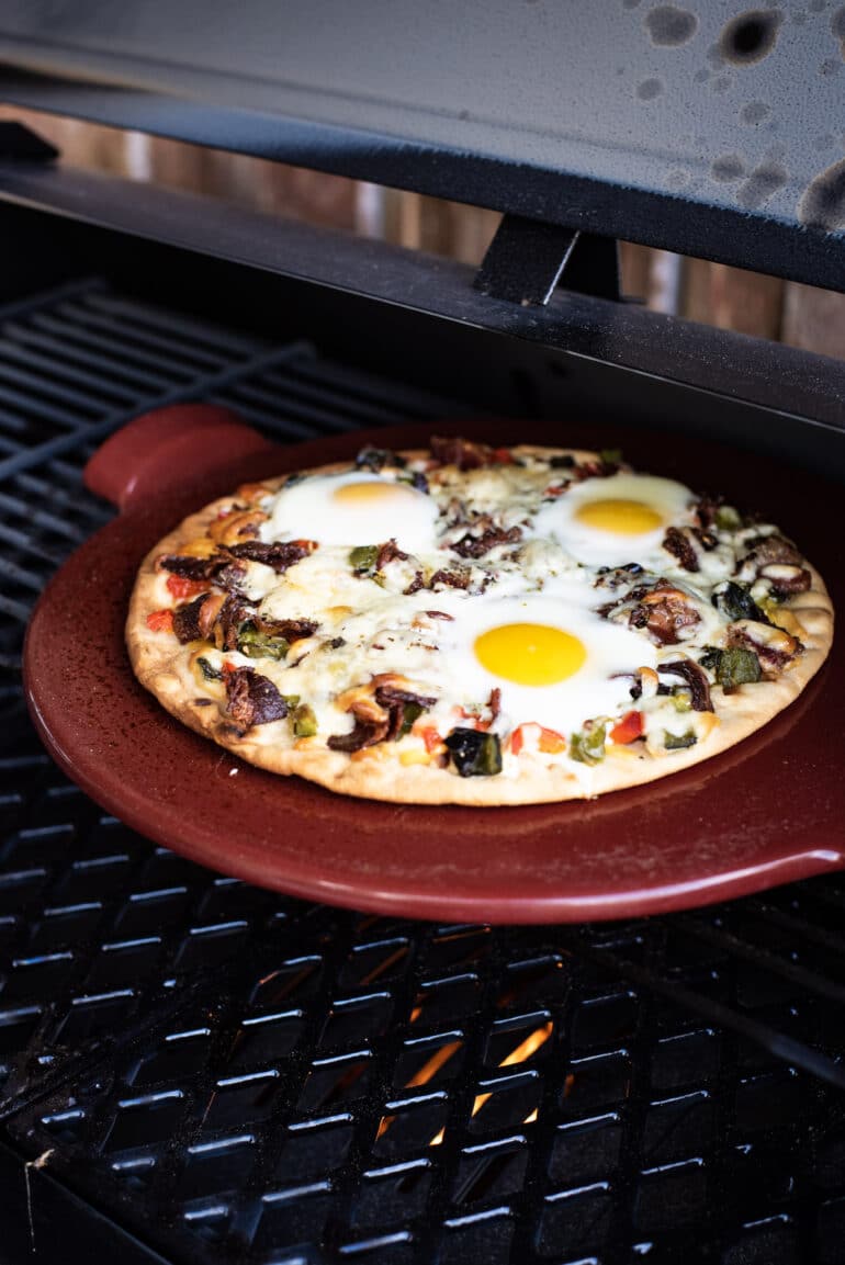 Grilled breakfast pizza with beef bacon and eggs