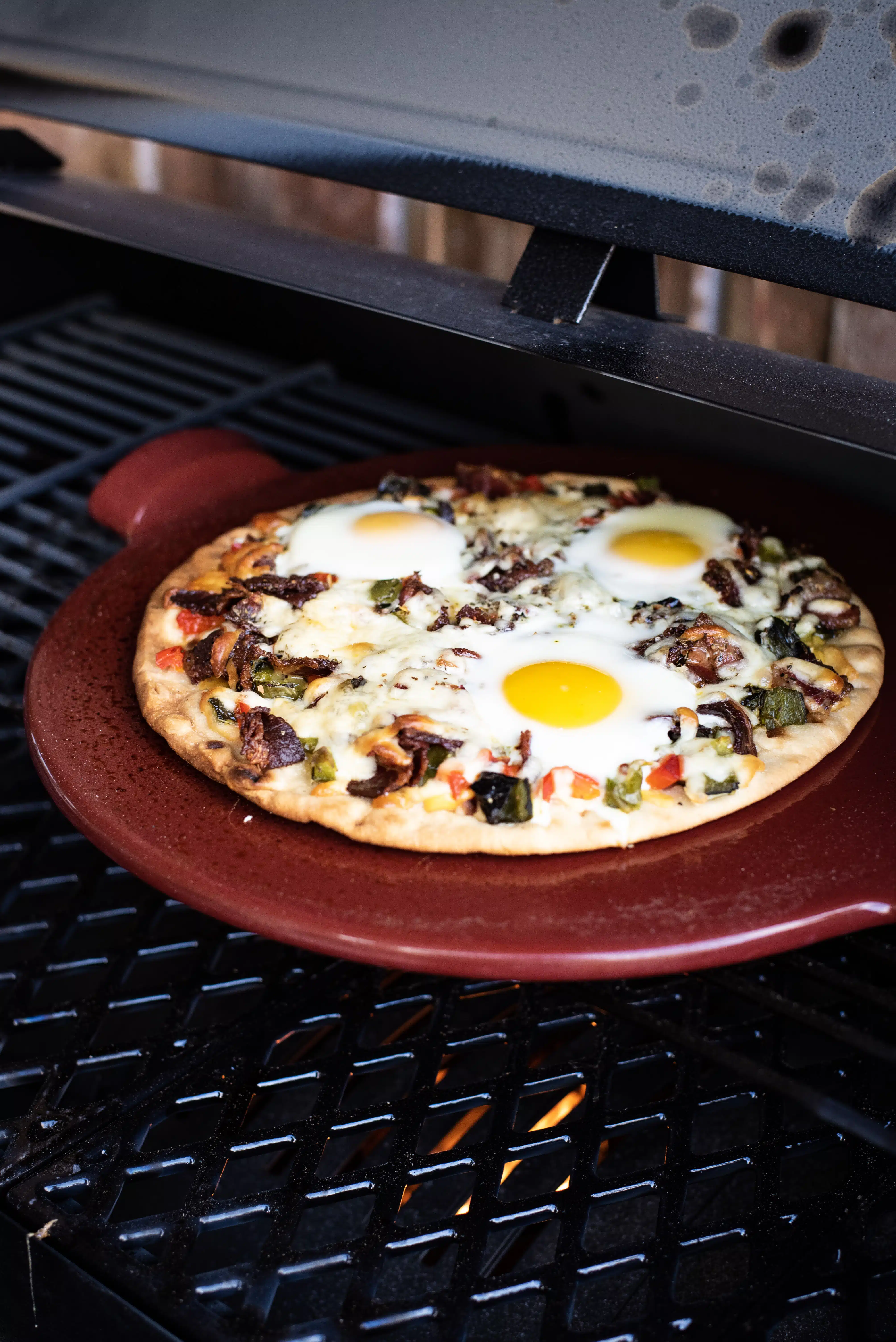 Grilled breakfast pizza with beef bacon and eggs