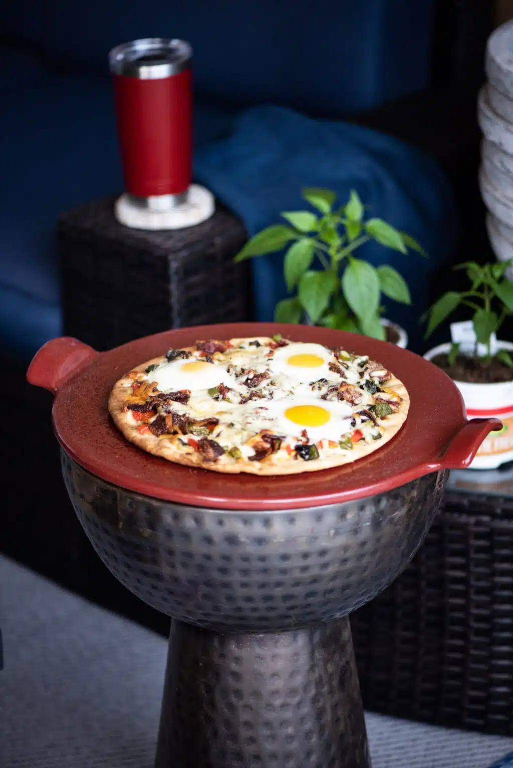 Grilled breakfast pizza served on a pizza stone in the backyard.