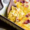 using a spoon to serve the beef bacon mac and cheese