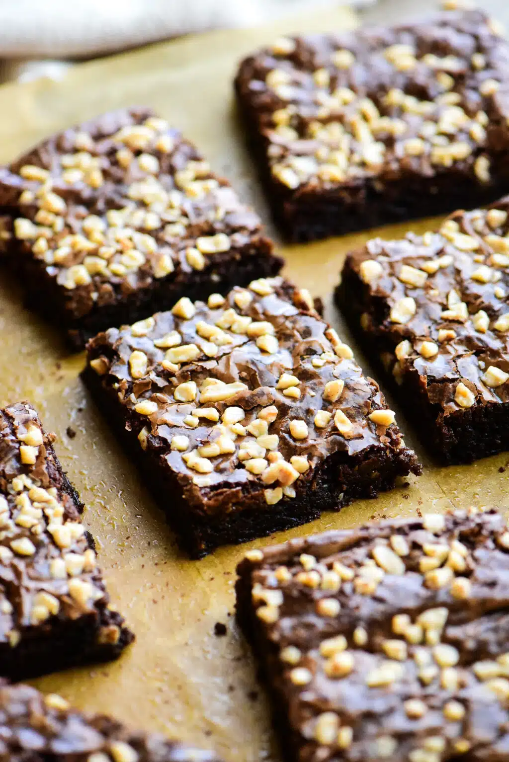toffee brownies that have been cut into squares  placed on brown parchment paper
