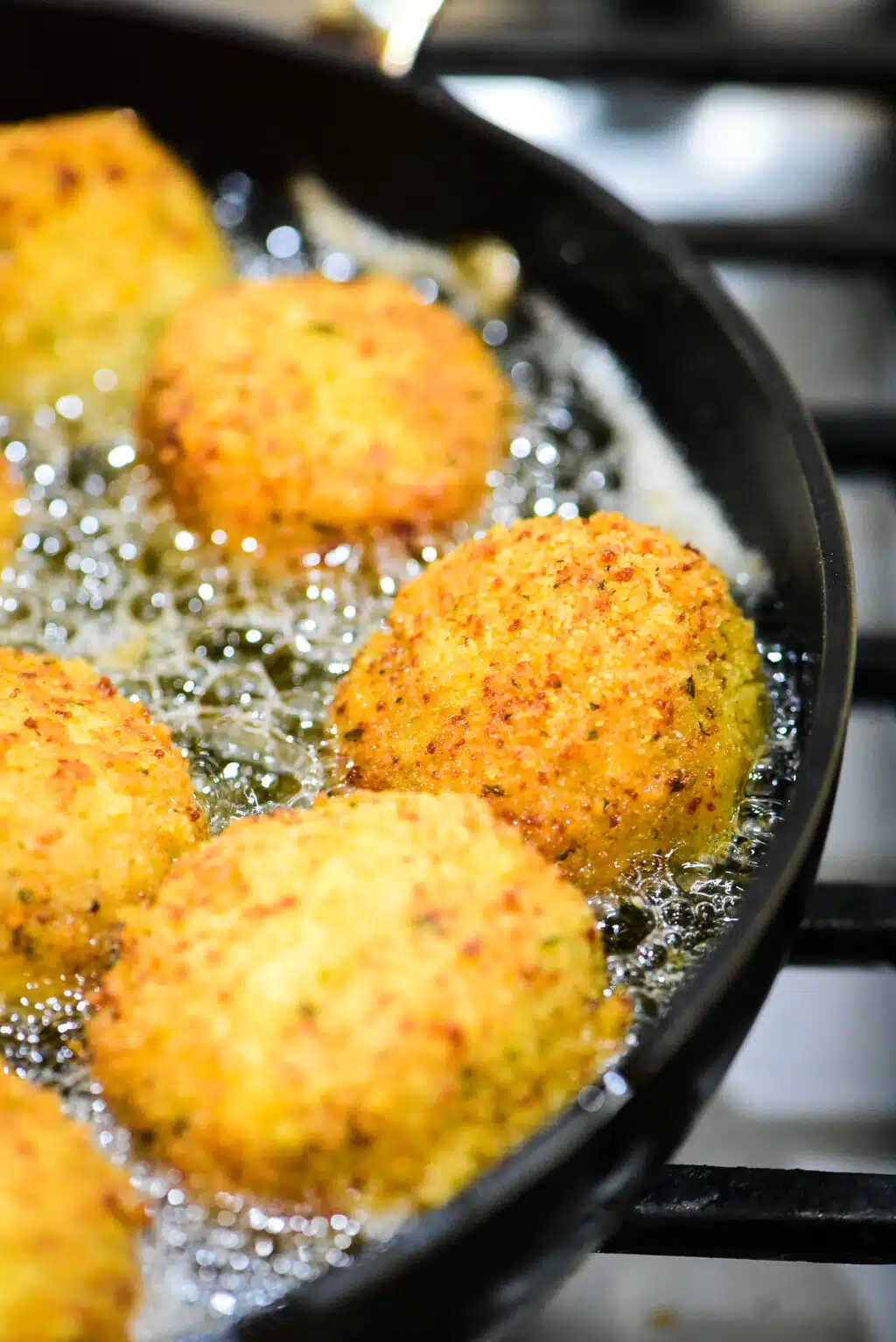 pan frying chicken meatballs being fried in a skillet
