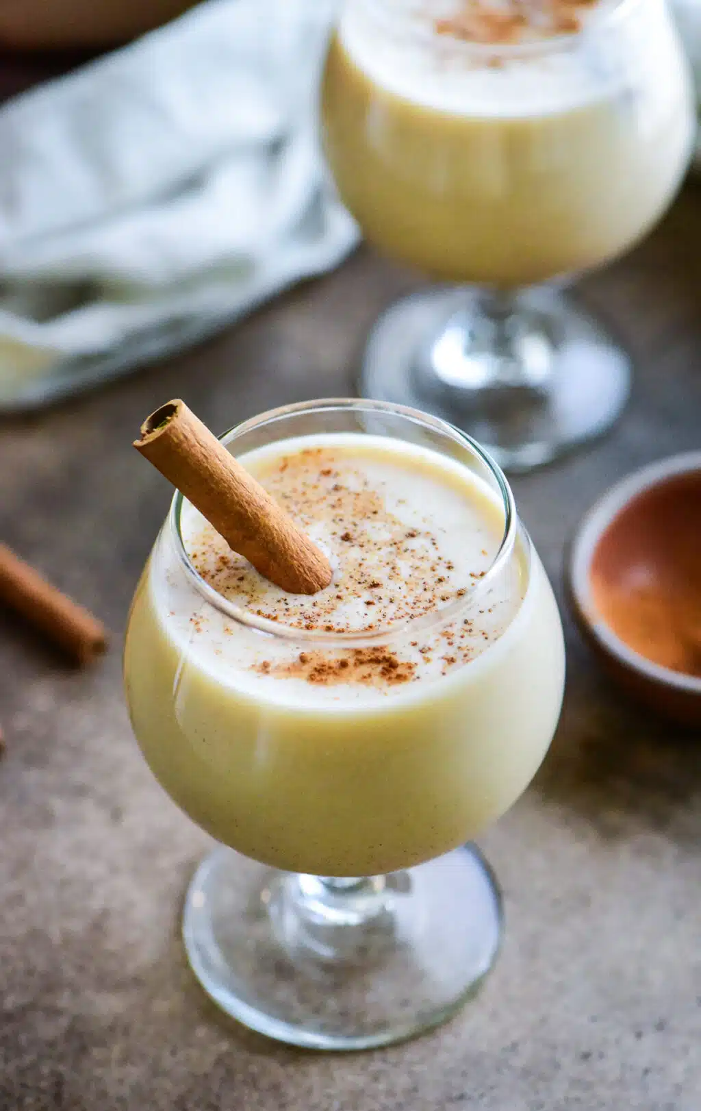 close up shot of a puerto rican coquito cocktail garnished with a cinnamon stick