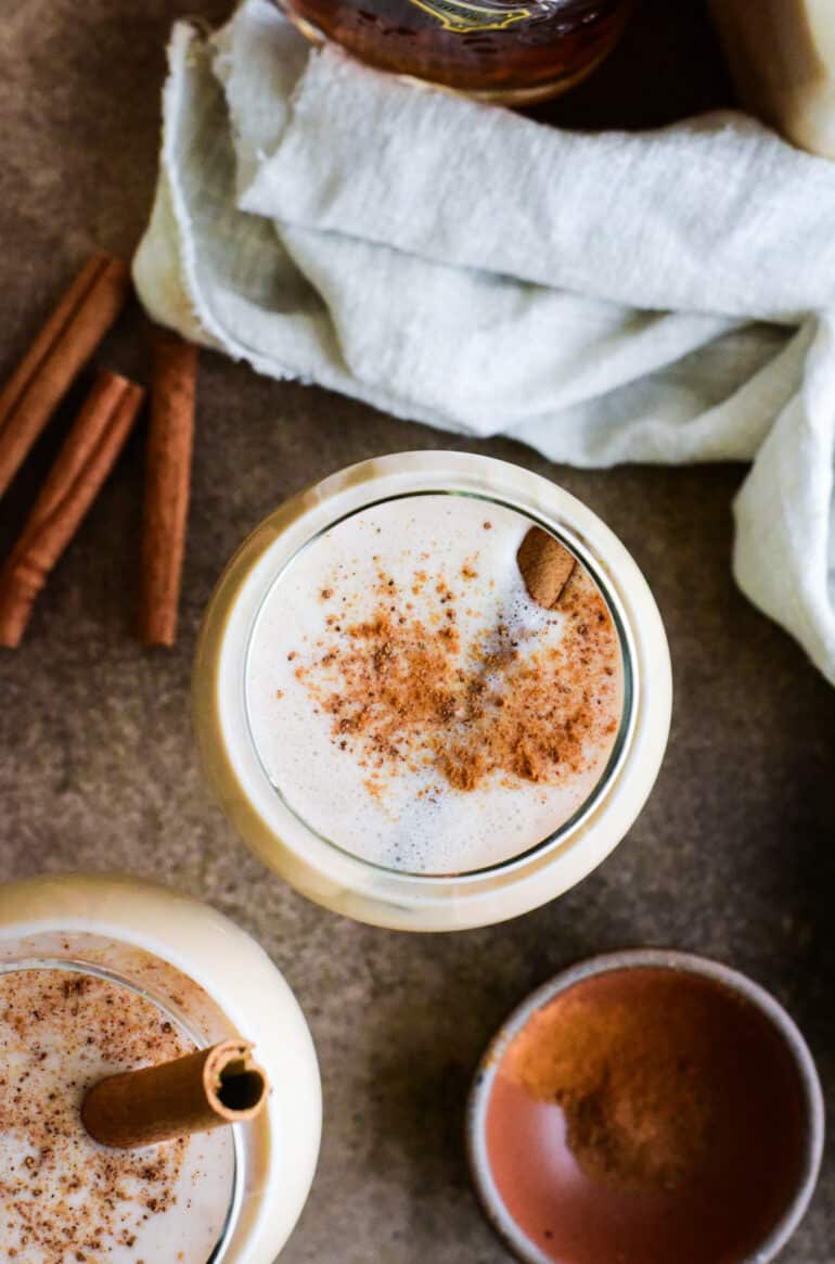 overhead shot of a puerto rican coquito cocktail garnished with a cinnamon stick