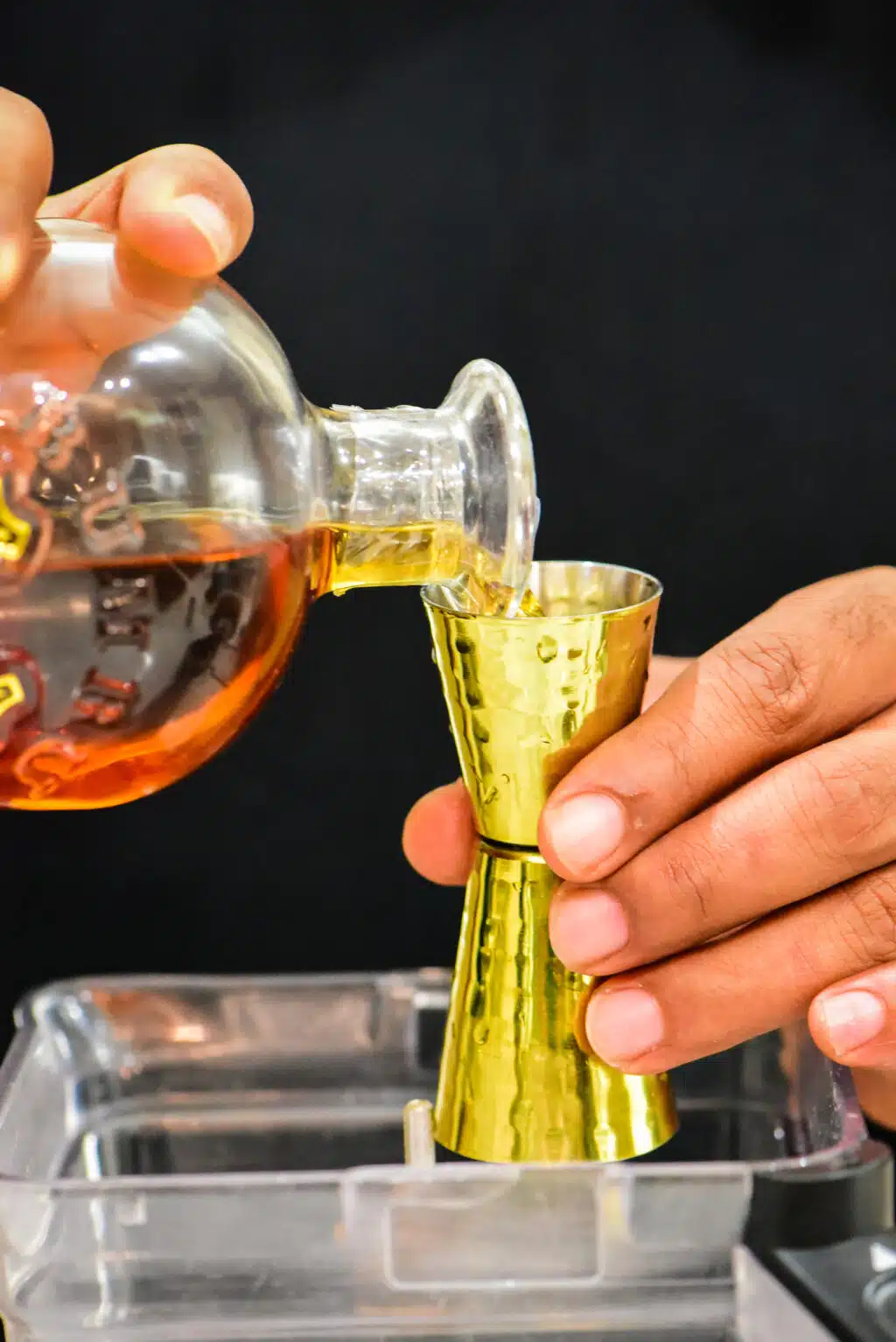 pouring dark rum into the blender