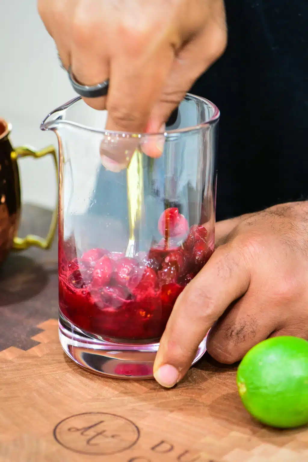 muddling cranberries in a glass