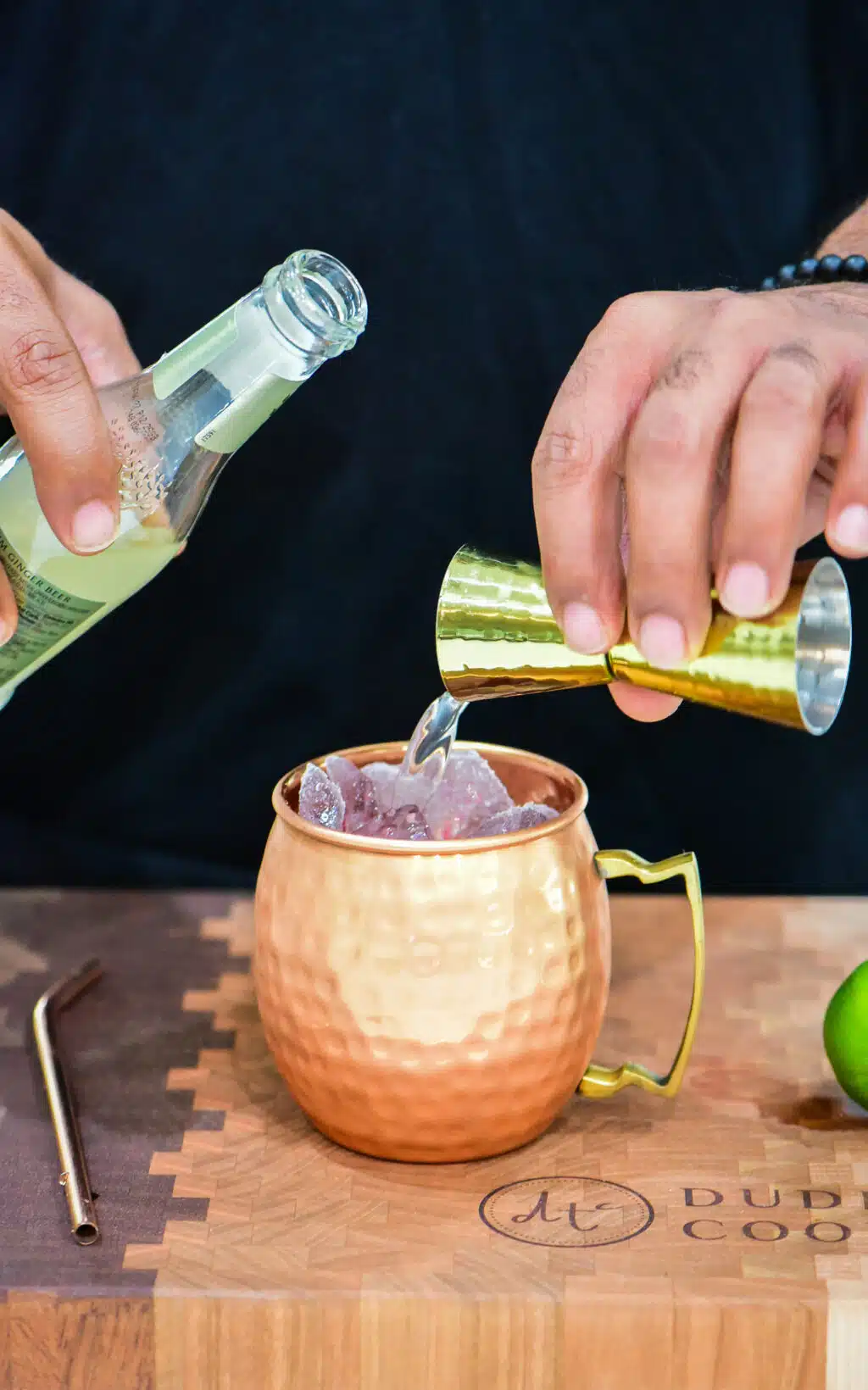 topping cocktail mixture with ginger beer
