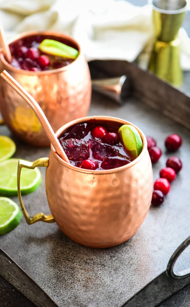 two cranberry Moscow mules served on a gray serving platter
