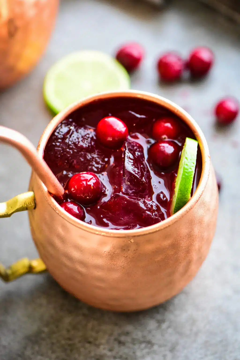 cranberry moscow mule garnished with fresh cranberries a lime wheel
