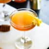 gin honey bee cocktail served in a glass with a lemon peel