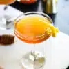gin honey bee cocktail served in a glass with a lemon peel